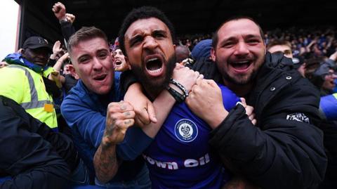 Tobi Adebayo-Rowling of Rochdale celebrates with fans following Devante Rodney of Rochdale (not pictured) scoring his team's second goal 