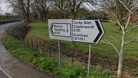 White sign with black writing directing motorists towards Corby Glen and Colsterworth