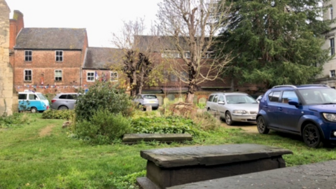 Cars parked in graveyard