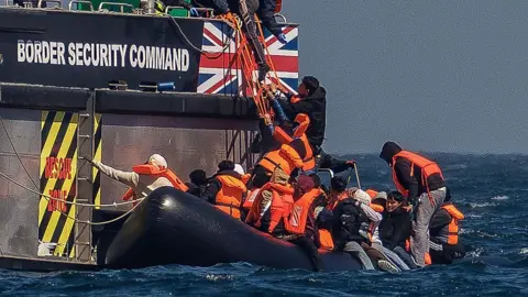 Men climbing from a small boat to a big one