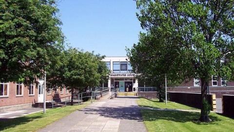 The two-storey concrete Grimsby Magistrates' Court building in the background with a pathway lined with trees at the front