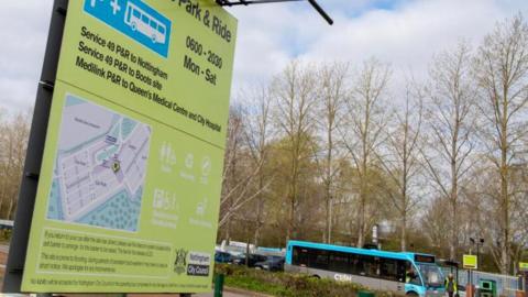 A totem sign at a park and ride site, with a bus in the background