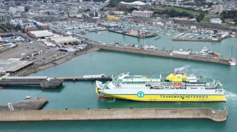 The Seven Sisters ship which is a large white and yellow passenger ferry. It is at port in Jersey. You can see how large it is in comparison to other boats in the harbour 