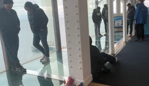 People waiting to be rescued stand on the 'Walk of Faith' glass floor at the top of Blackpool Tower.