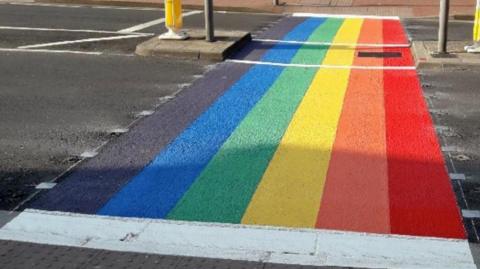 A rainbow flag crossing