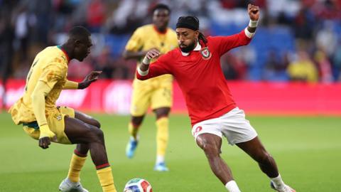 Ghana's Jonas Adjetey challenges Sorba Thomas of Wales 