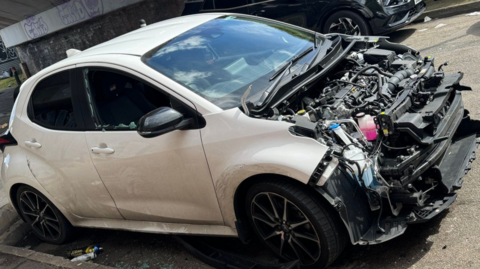 White car with bonnet lid missing and window smashed