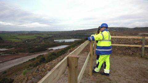 A picture of two workers stood overlooking part of the mine. 