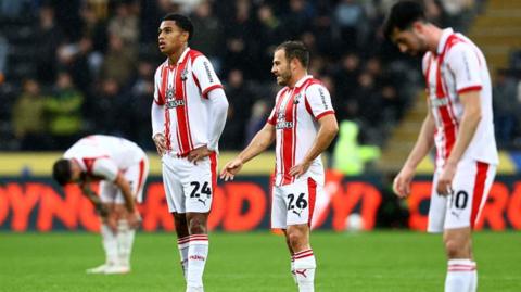 Southampton players look dejected on the pitch at Hull's MKM Stadium