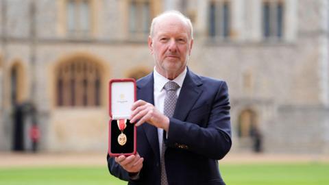 Sir Alan Bates holding his honour