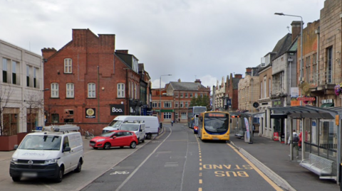 A street scene with cars and buses 