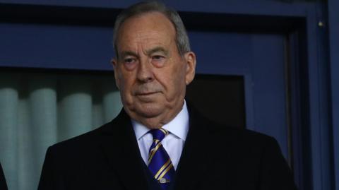 Shrewsbury Town chairman Roland Wycherley looks down from the hospitality seats in the stand