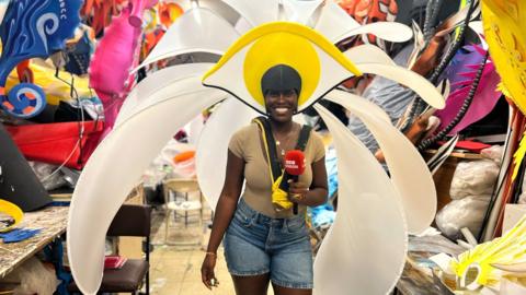 Aminata Kamara smiles at the camera whilst wearing a flowery carnival costume