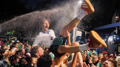 England fan being thrown into the air as beer is thrown around him in Mexico City