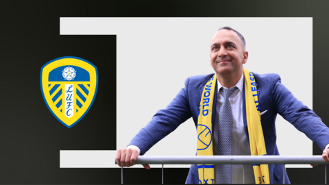 Leeds chairman Paraag Marathe stands with Leeds scarf around his neck in front of white and black background with club badge
