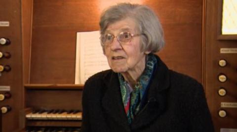 Joycelyn Hocking sitting in front of a church organ