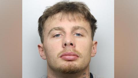 A police mugshot of Billy Mole, who has short blonde hair and neck tattoos.