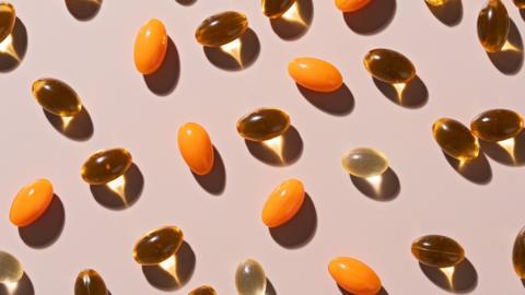 Various soft gel capsules on beige background