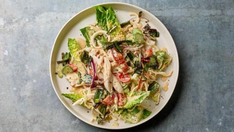 A plate with chicken, greens and tomatoes salad