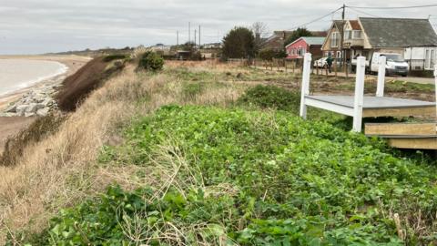 The cliff edge at Pakefield with rock defences close to the shoreline and the remnants of a veranda on the clifftop 