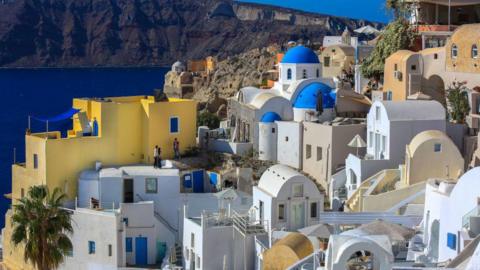 Whitewashed buildings and churches with blue domes on Santorini 