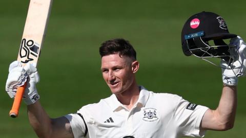 Cameron Bancroft raises his bat and helmet to the crowd
