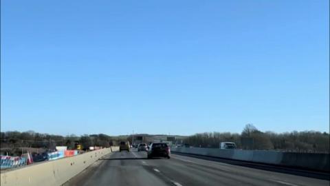 A motorway with cars and a blue sky.