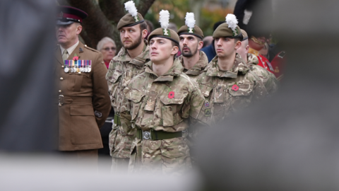 Soldiers in army uniform stand on parade