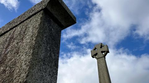 Looking up to the sky with two war memorials captured in the picture 