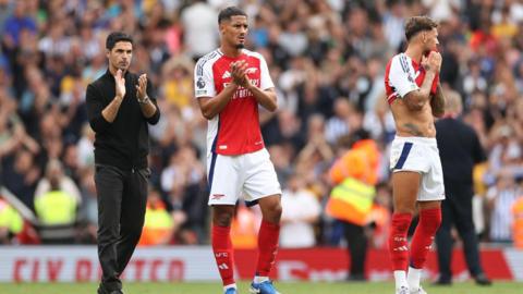 Mikel Arteta, Manager of Arsenal and William Saliba of Arsenal applaud the fans