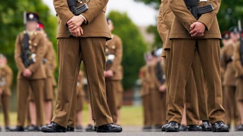 A stock image shows the legs and feet of junior soldiers lining up and holding guns at the Army Foundation College in 2015