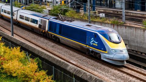 A blue, white and yellow train with "Eurostar" on the front.
