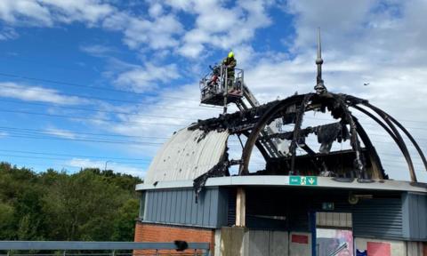 Firefight on cherrypicker above burned structure