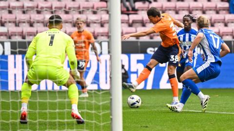 Cardiff's Perry Ng unleashes a goal-bound shot against Wigan