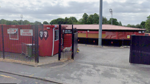 The front entrance of Salford City's stadium with a red cabin on the left hand side