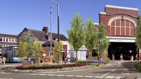A CGI street scene with tree and flowers on an island surrounded by a grey tarmac road. There is a red-brick bus station in the background.