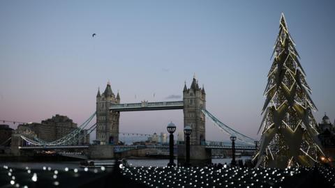 A wintery shot of Tower Bridge with white Christmas lights in the foreground.