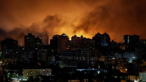 An explosion of a drone lights up the sky over the city during a Russian drone strike
