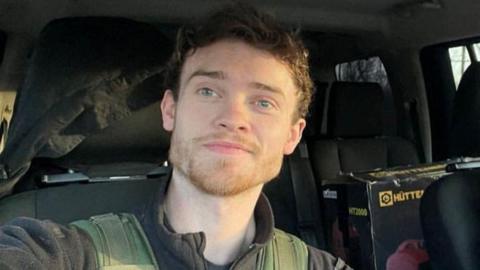 A smiling Chris Parry in a vehicle.
