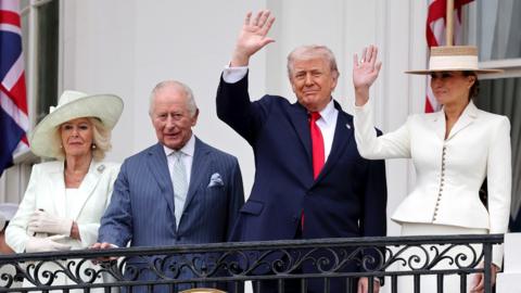 The Queen, King, Donald and Melania Trump stand on the White House balcony in formal attire on Tuesday.