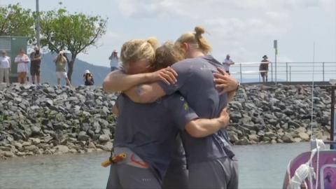 Three brothers embrace after rowing 9,000 miles