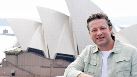 Jamie Oliver stands in front of the Sydney Opera House