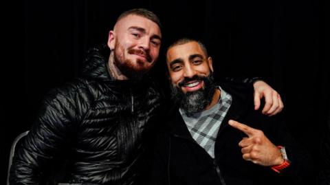 Lewis Crocker and Huzaifah Iqbal embrace while posing for a photo