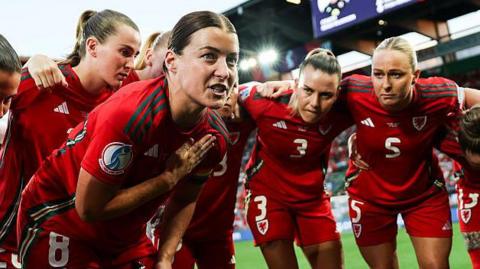 Wales captain Angharad James speaks to her team-mates (L-R: Carrie Jones, Gemma Evans, Rhiannon Roberts) prior to the Euro 2025 match against England