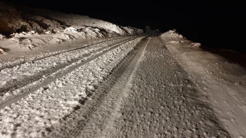 Snow falling on an Exmoor road