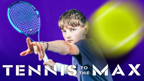 a boy holding a tennis racket, pointing at the camera. a tennis ball flies past