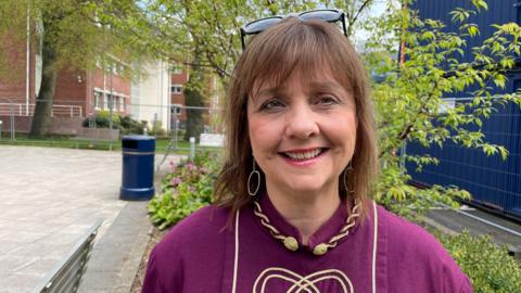 Llun o Llinos Roberts, Cadeirydd pwyllgor gwaith yr Eisteddfod Genedlaethol yn Wrecsam, yn ei gwisg ar gyfer seremoni'r Orsedd