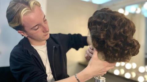University of Northampton student Liam Gambrell, studying hair, make up and prosthetics for stage and screen, looking at a wig