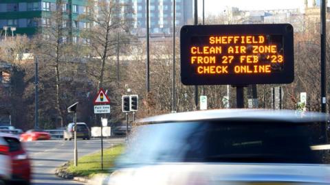 Cars driving past an electronic sign