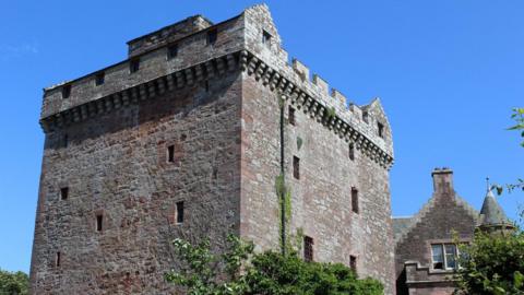 A classic Tower House building against a bright blue sky